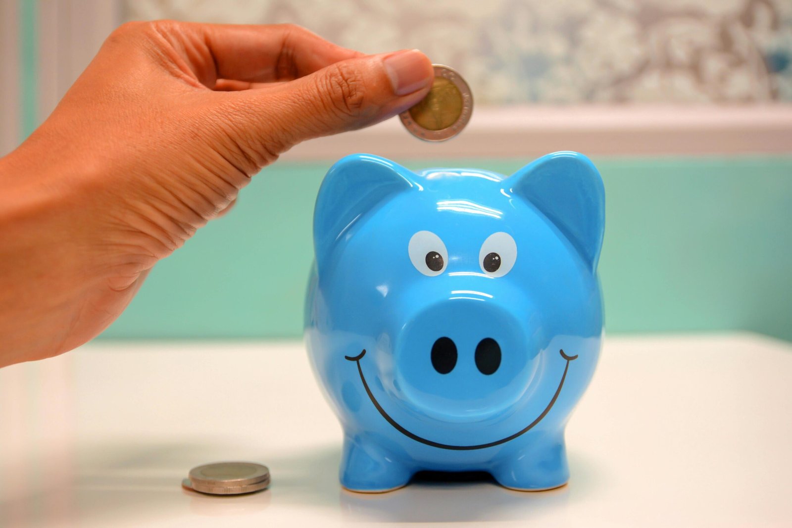 Illustration showing child depositing coins into a piggy bank shaped like a house