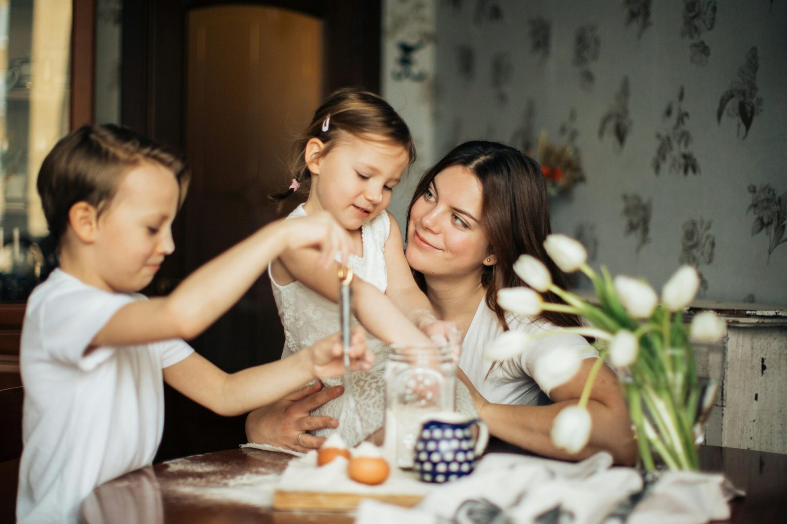 Parent and child smiling while reviewing banking documents at kitchen table