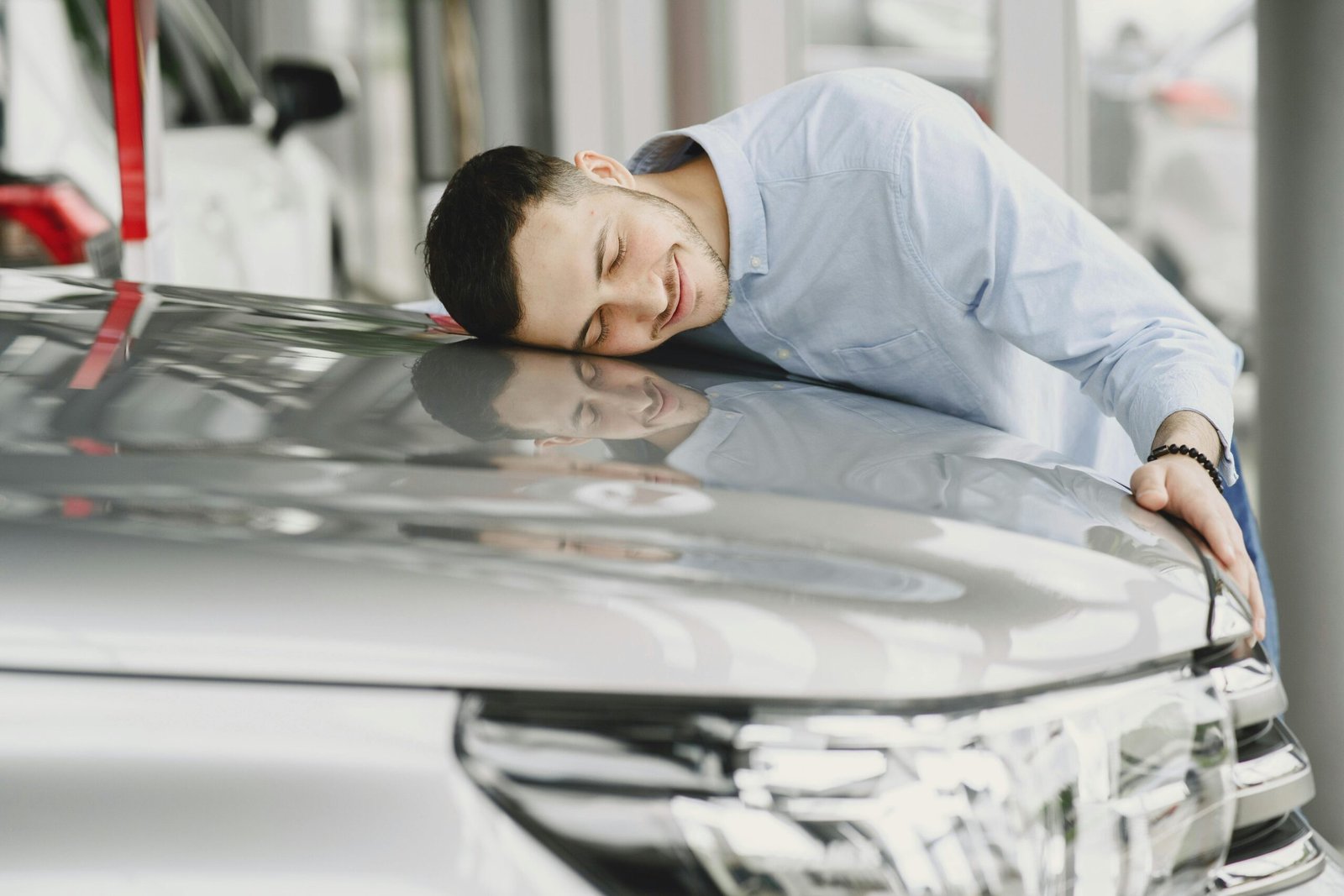 Teenage girl smiling beside a shiny new car purchased with savings