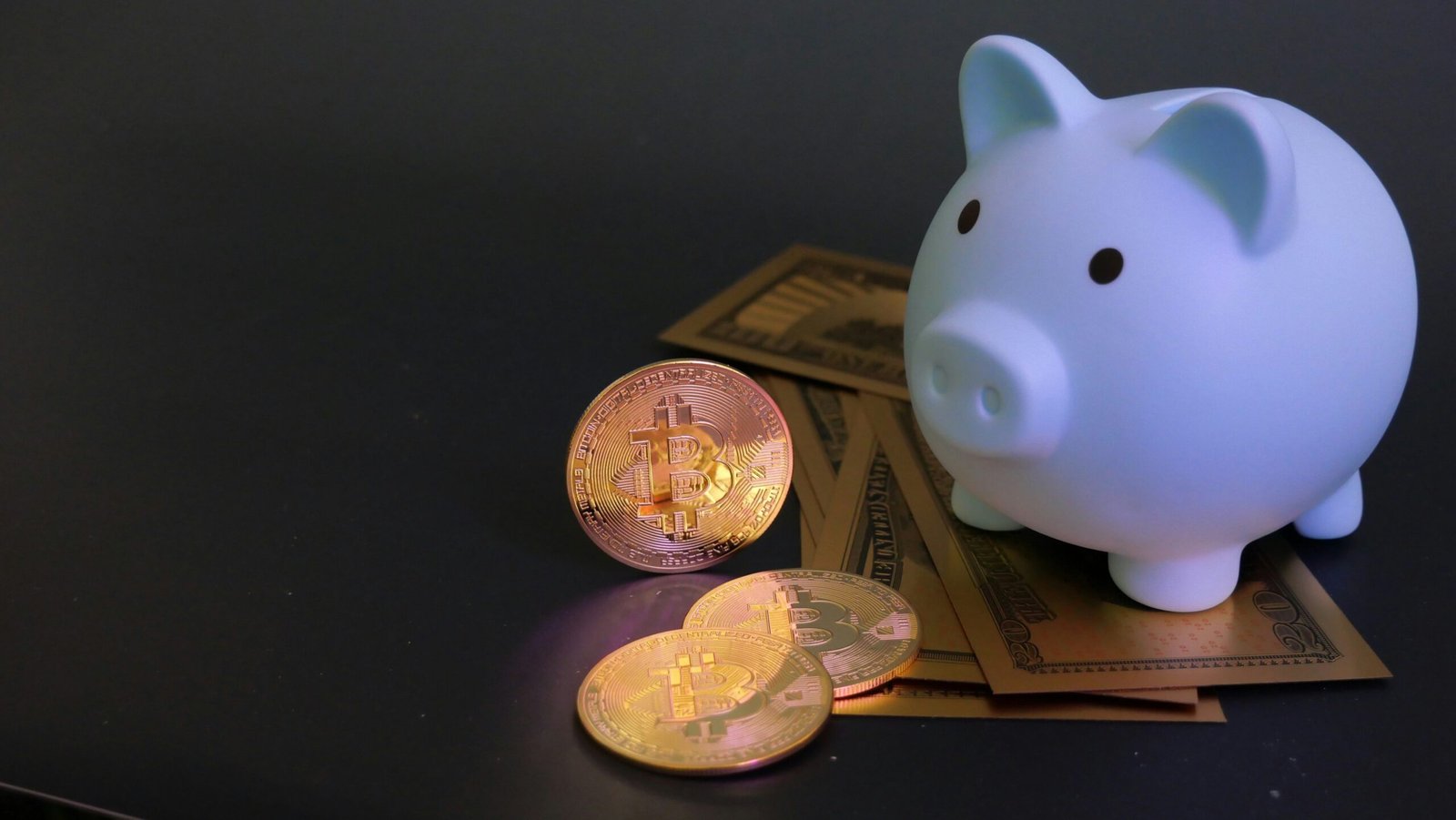 Photograph of smiling teenage saver holding piggy bank next to laptop displaying savings growth graph
