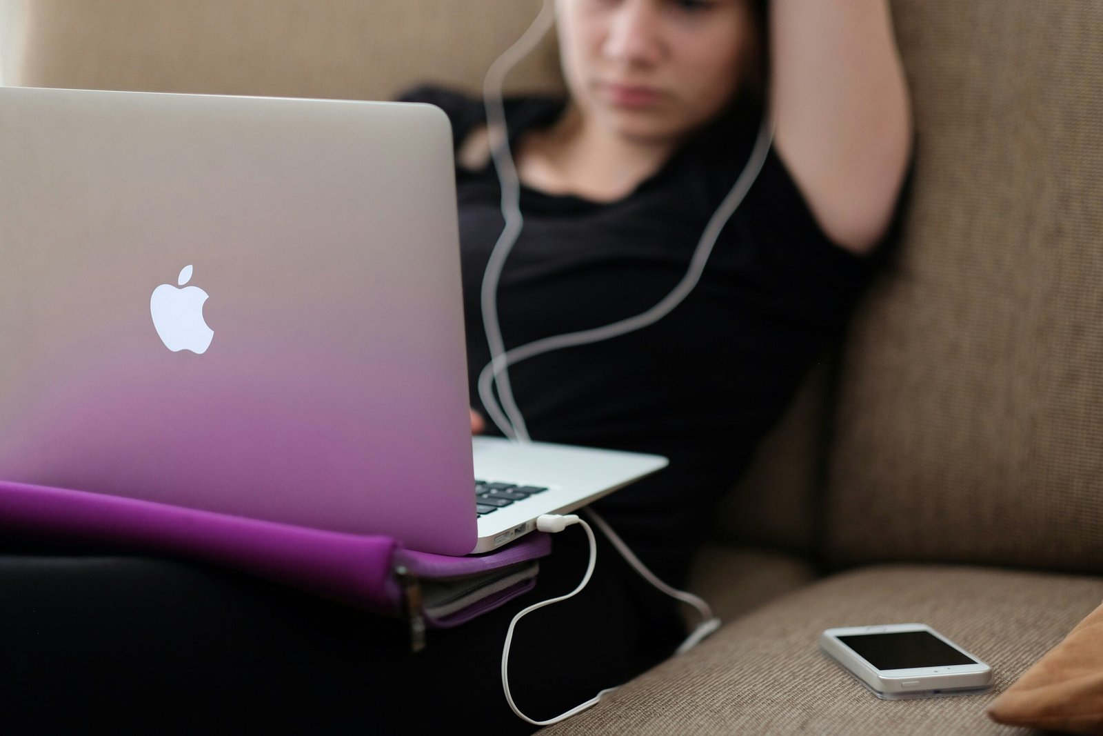 Teenager smiling next to a laptop purchased using funds from her savings account